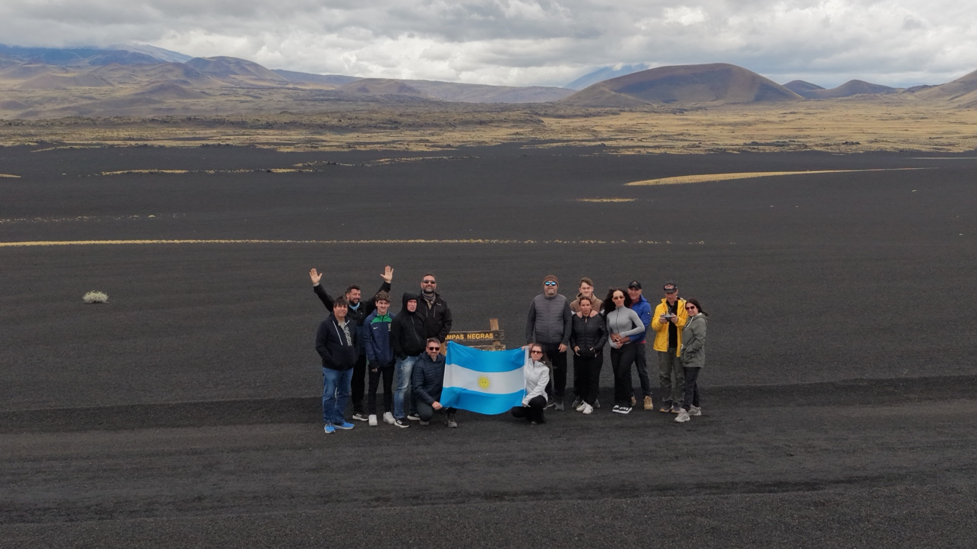 Grupo com a bandeira argentina no campo de lava das Pampas Negras